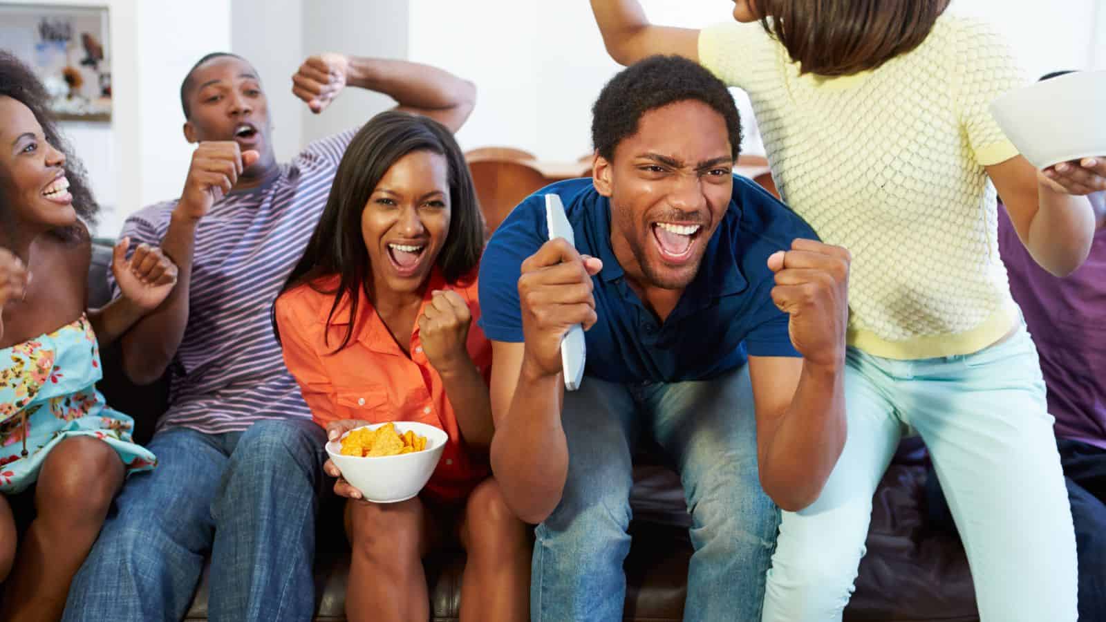 black family watching sports on a couch