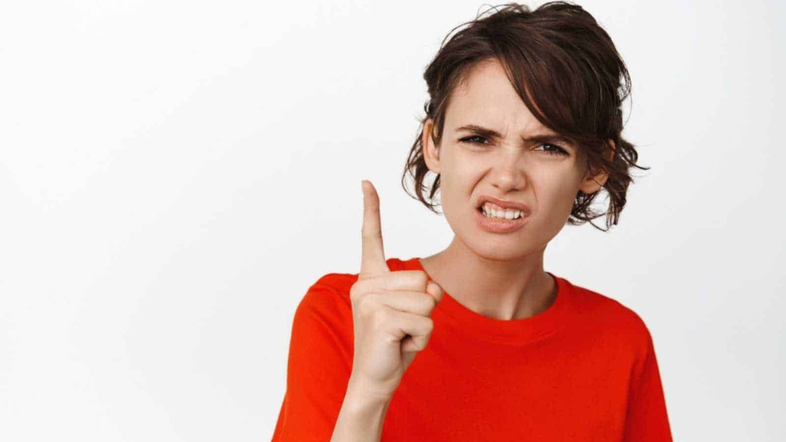Disappointed and frustrated young woman shaking finger