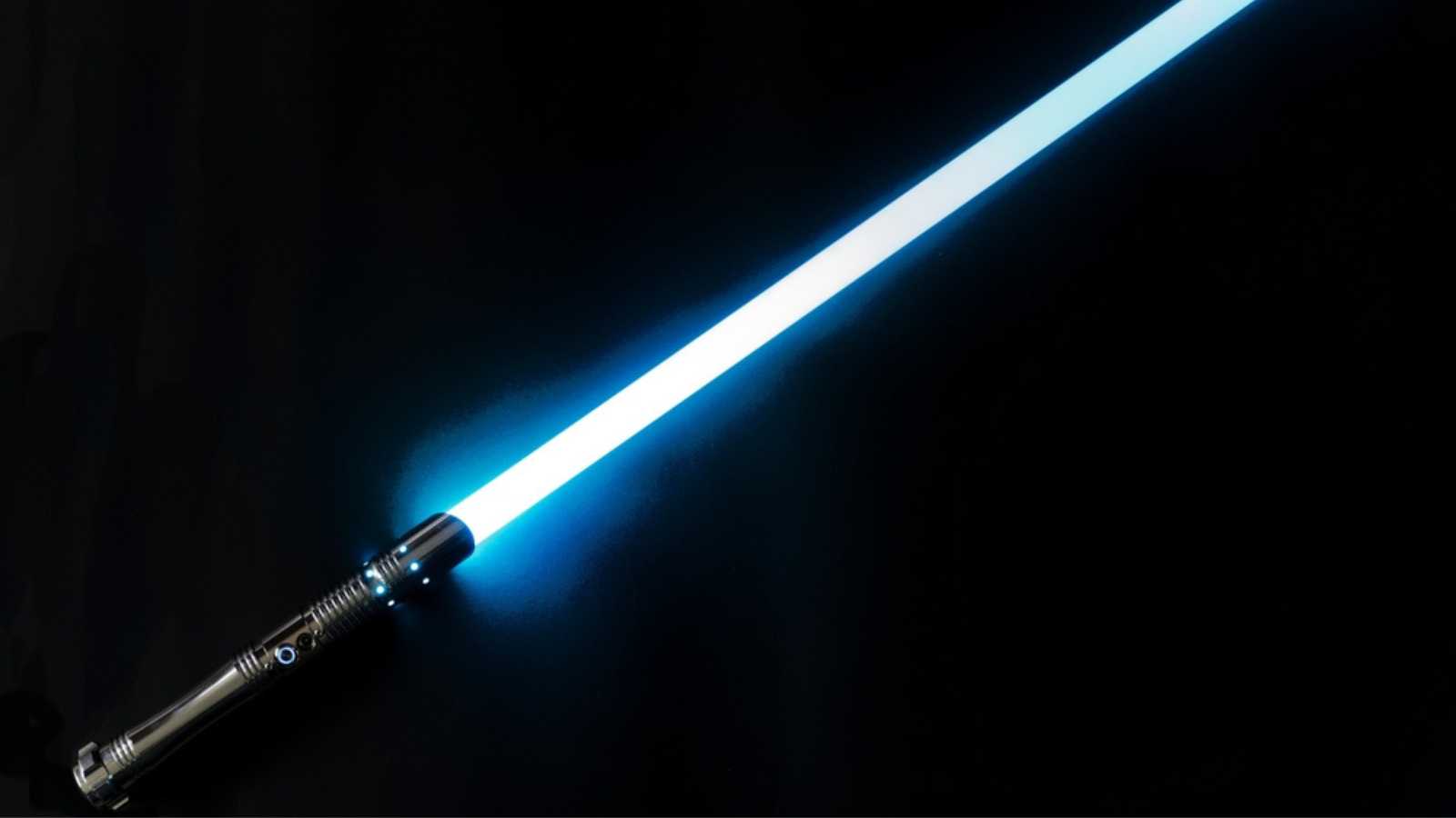 Colorful glowing laser sword blade with shiny silver metal grip against black background. Photo taken January 26th, 2023, Zurich, Switzerland.