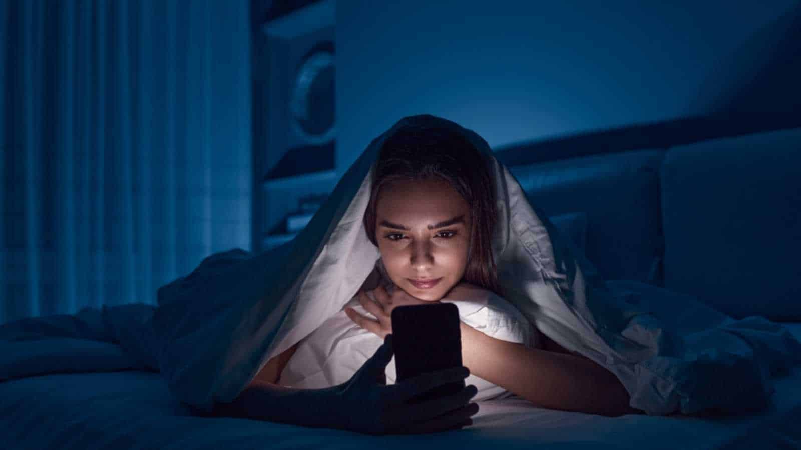 Woman scrolling mobile at night