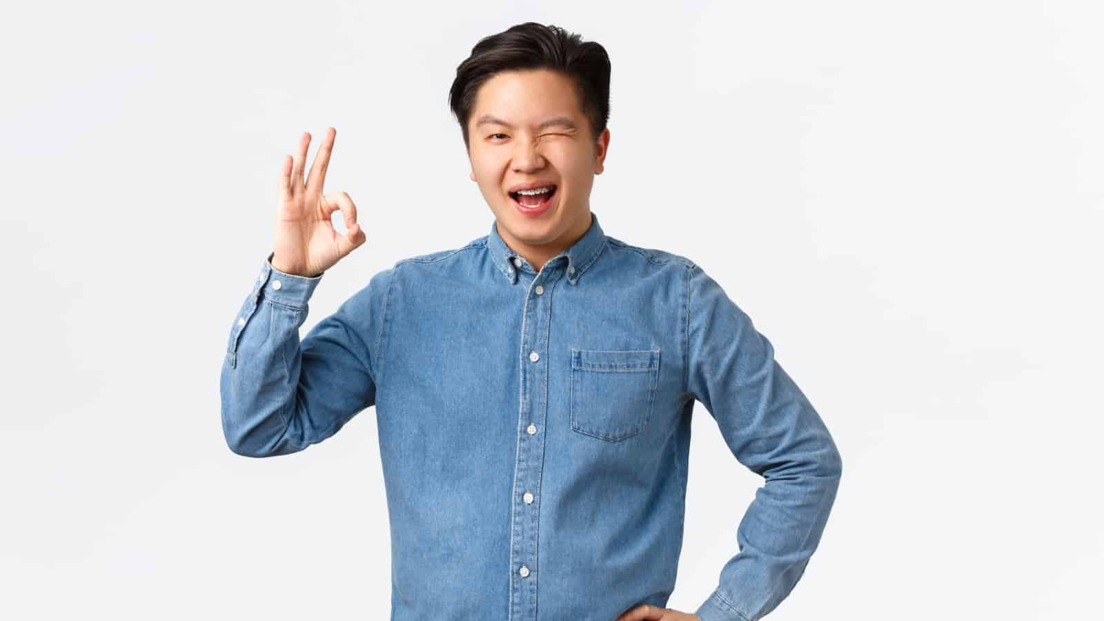confident Asian man winking OK Shutterstock
