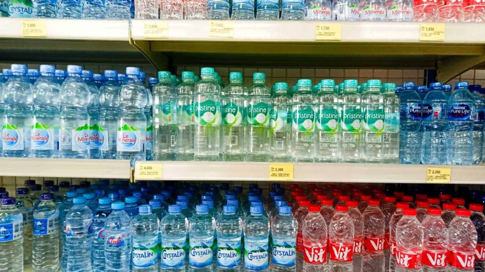 Yogyakarta, Indonesia - March 30, 2023. Mineral water arranged on the shelves in supermarket. Bottled water sold in supermarket. Various brand of mineral water in Indonesia.