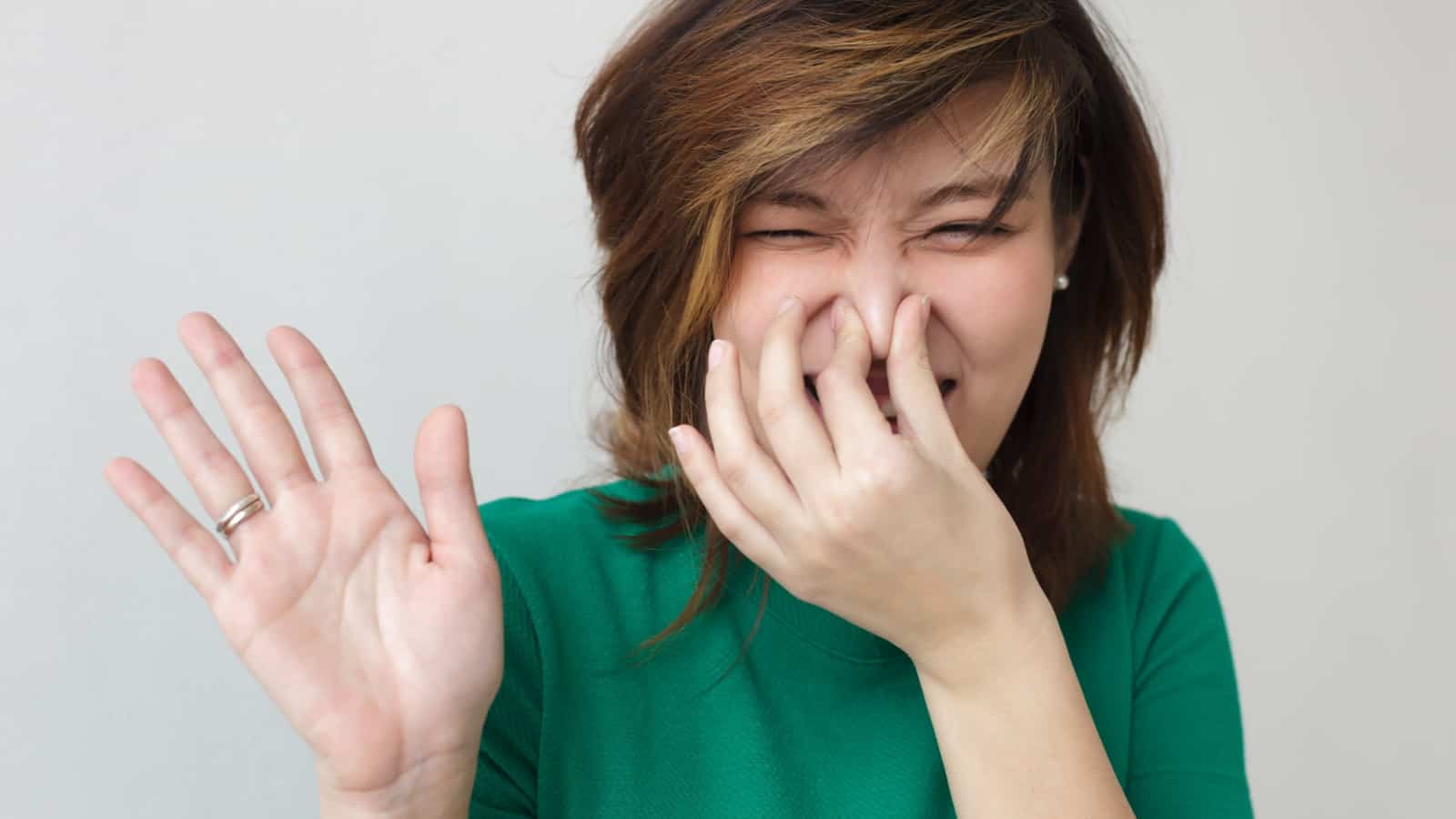 woman plugging nose stink