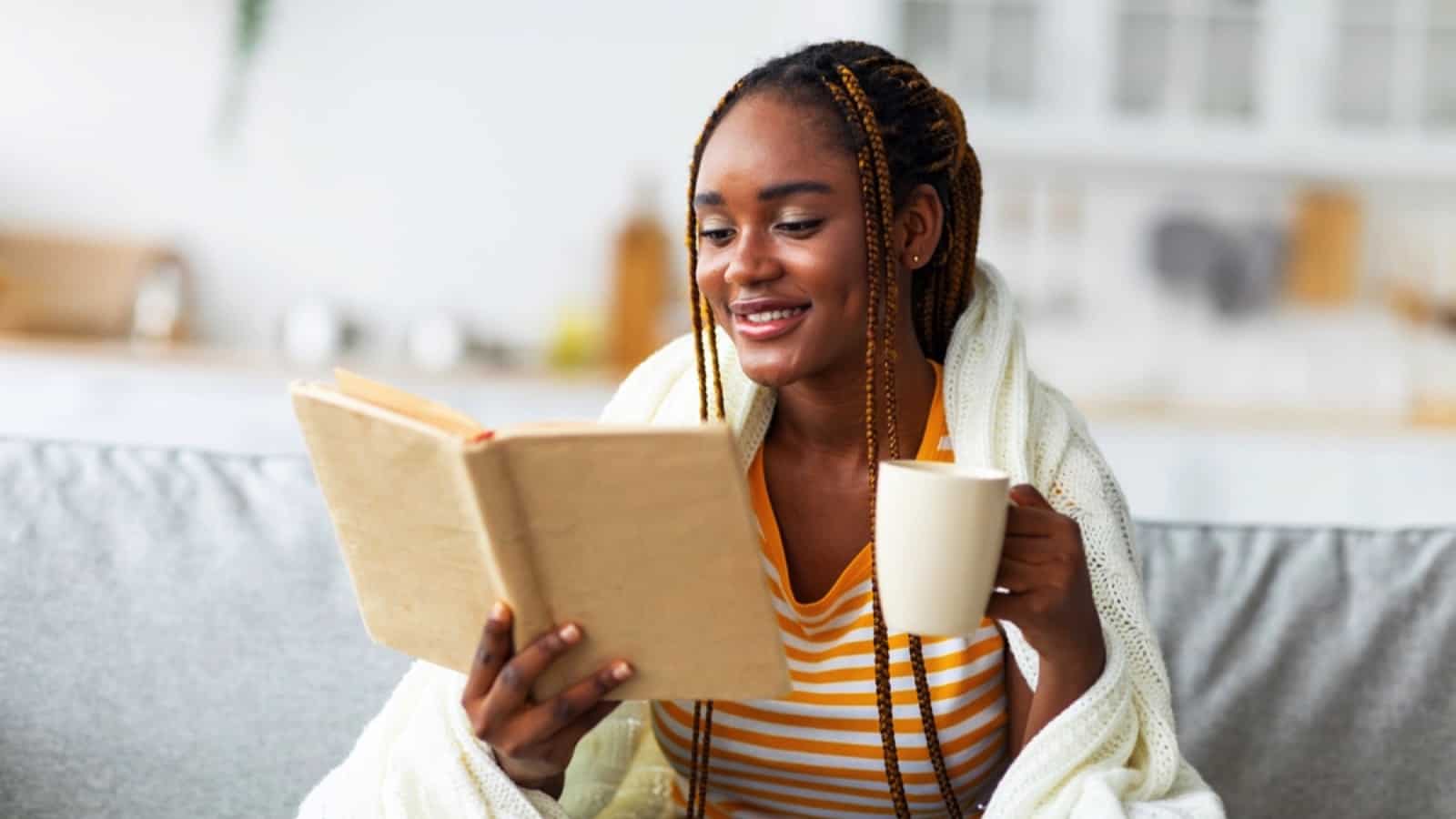 African woman with coffee and book