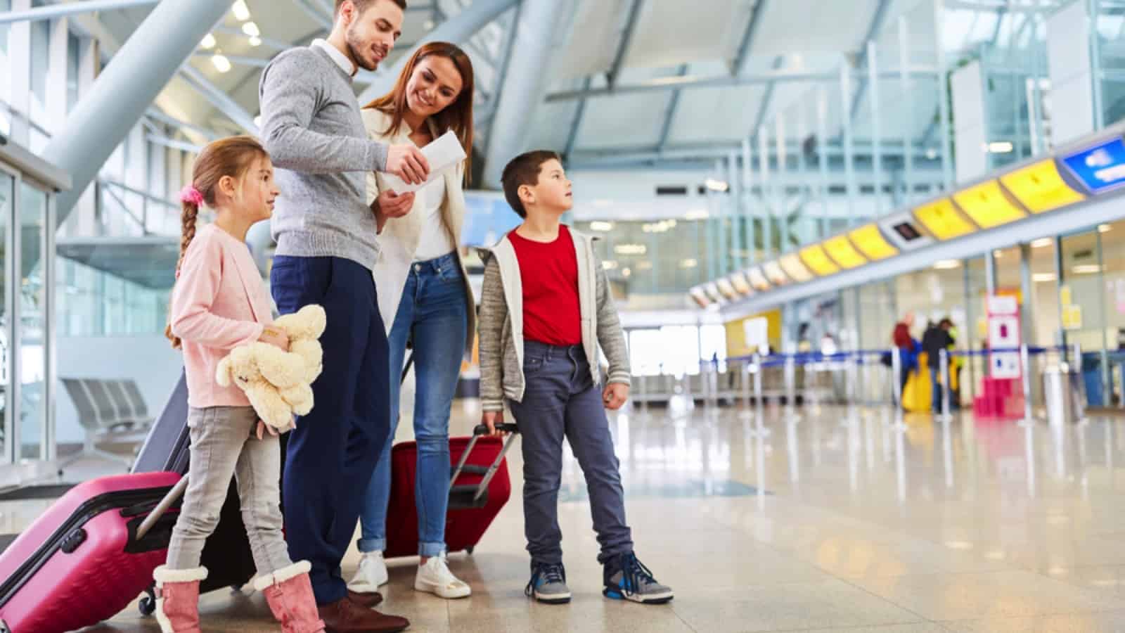 Family in airport checking tickets